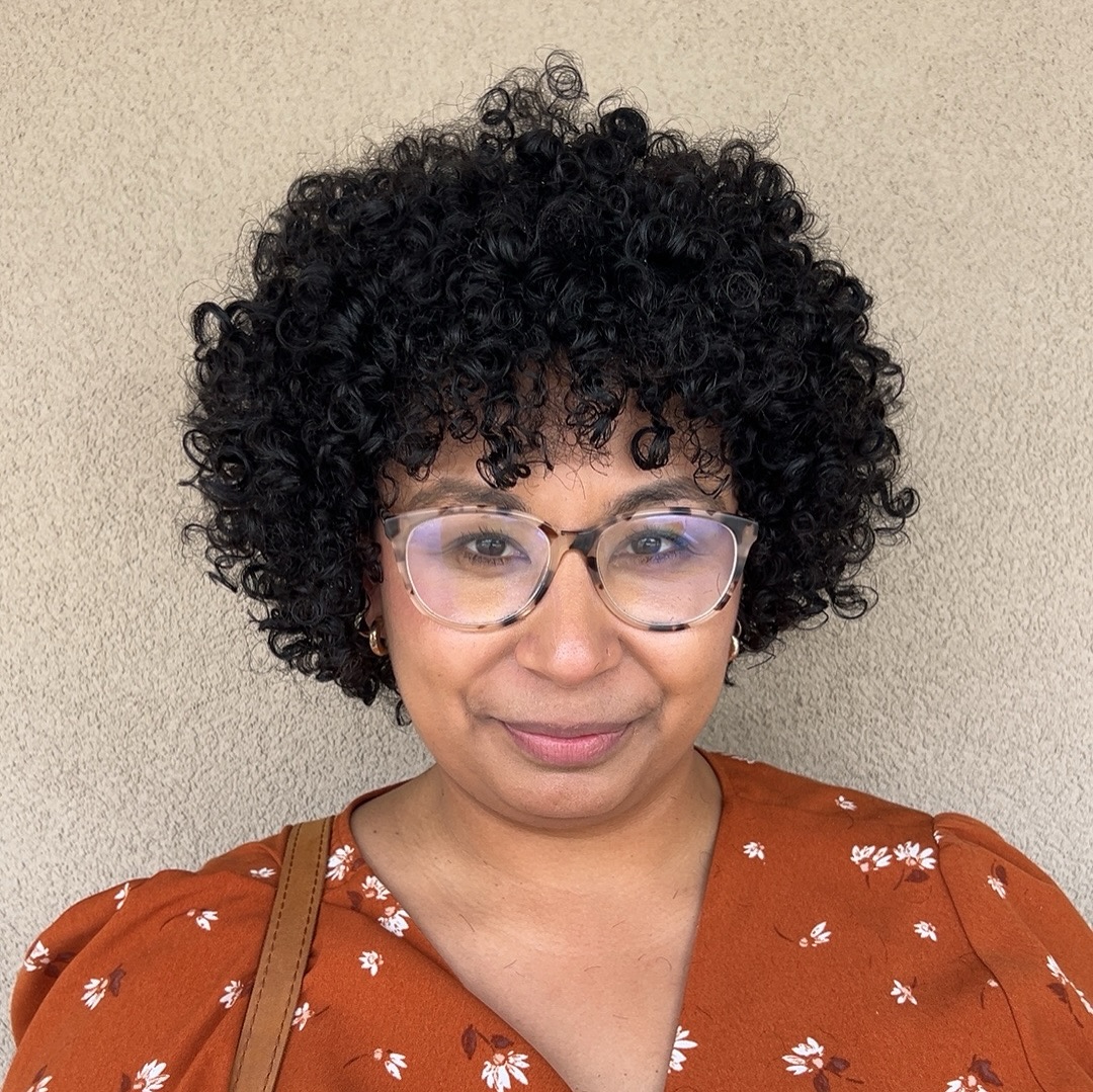 12. Curly Crown Of Joy: Embracing Playful Volume with Chic Bangs