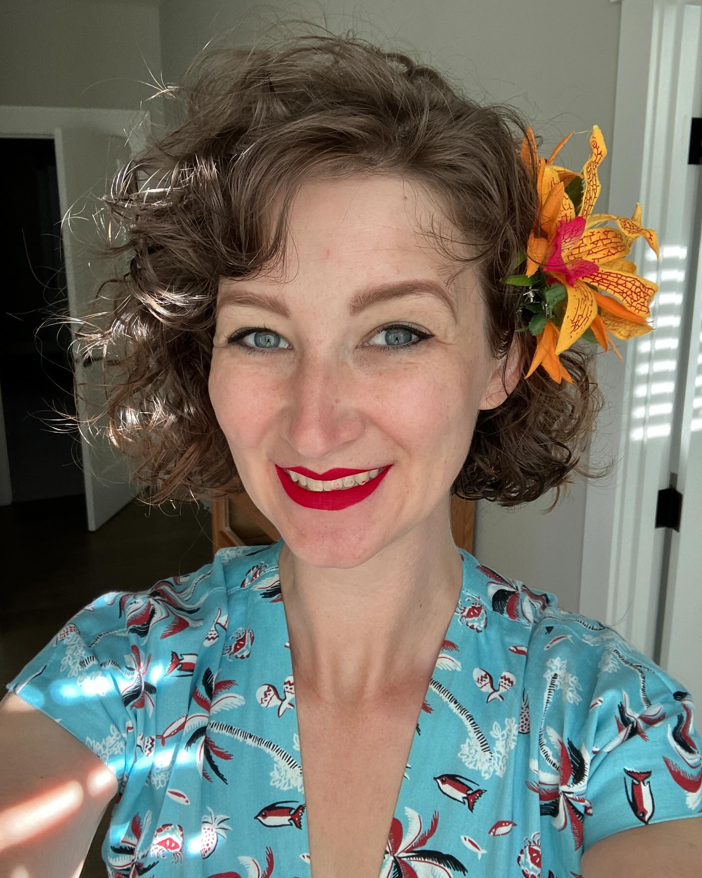20. Tropical Whimsy: Short Curly Bangs with a Splash Of Floral Flair