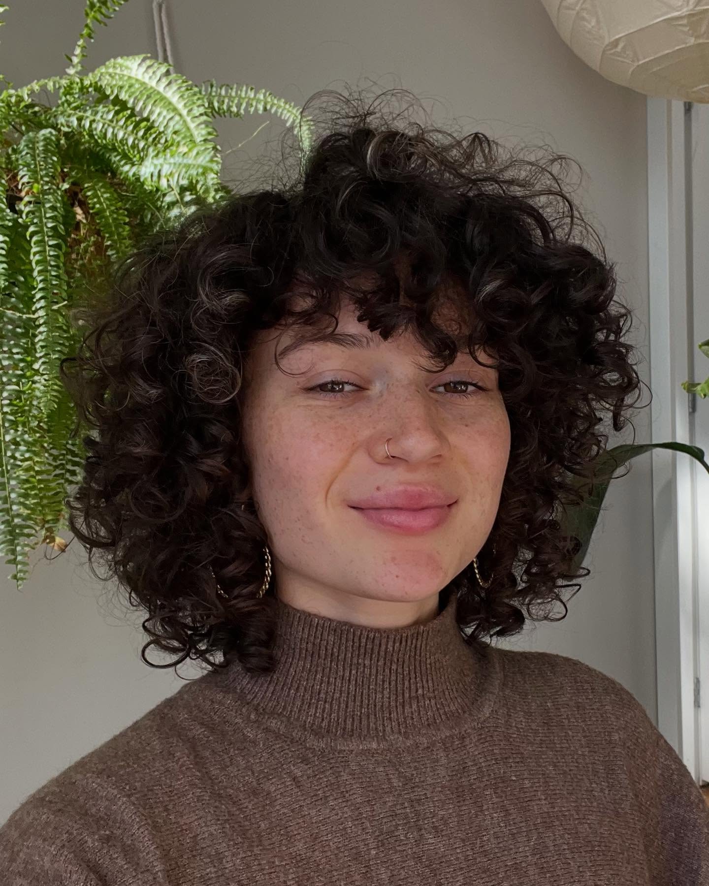 13. Embrace the Whimsical: a Fluffy Curly Crop with Playful Bangs