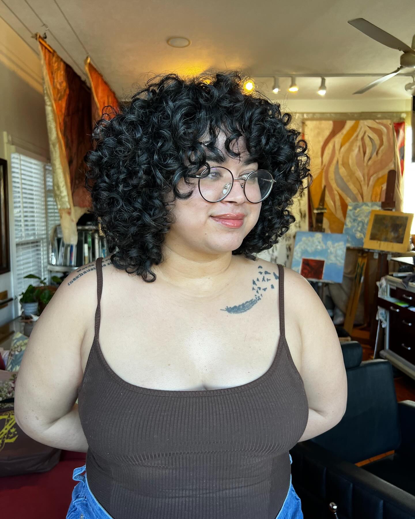 27. Curly Confidence: a Playful Ensemble Of Defined Curls and Whimsical Bangs
