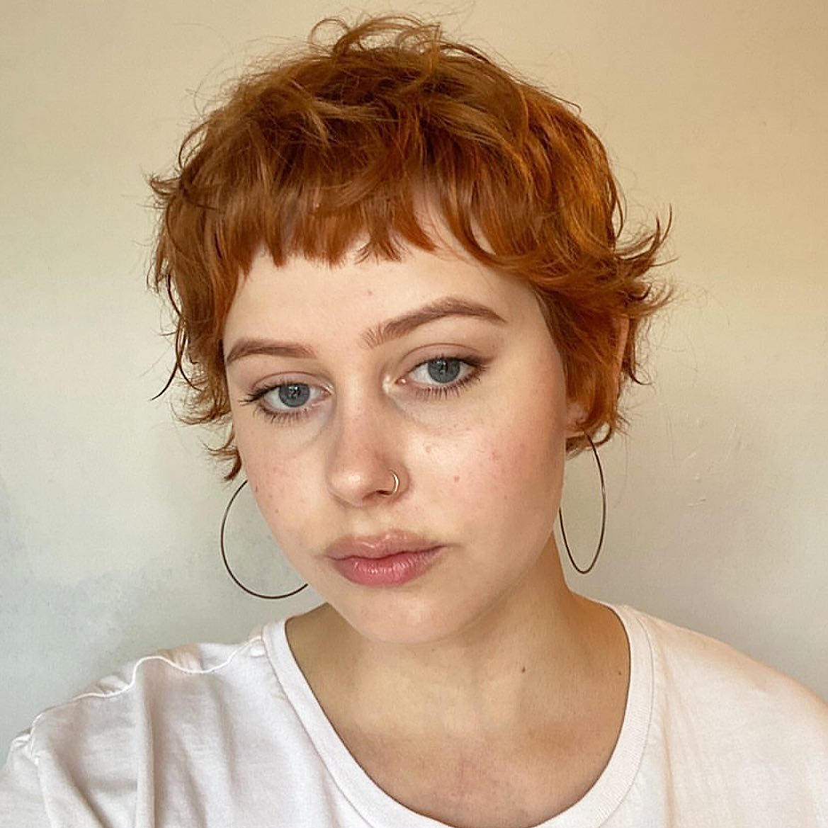 5. Short Curly Pixie Cut with Wispy Bangs