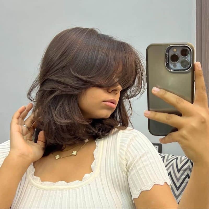 14. Modern Choppy Lob with Wispy Bangs