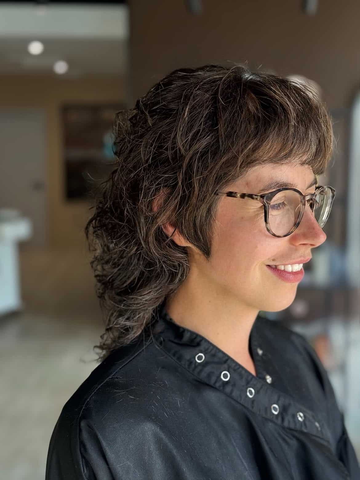 22. Curly Brunette Mullet with Baby Bangs