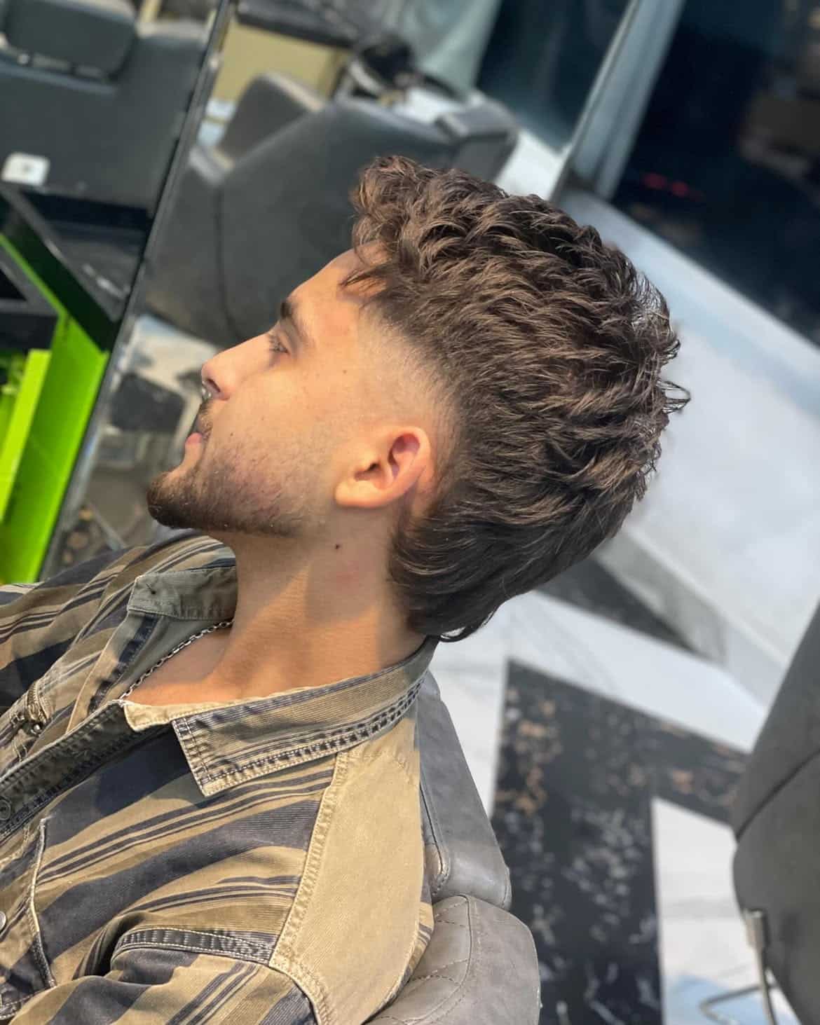 26. Curly Burst Fade Mullet with Textured Fringe