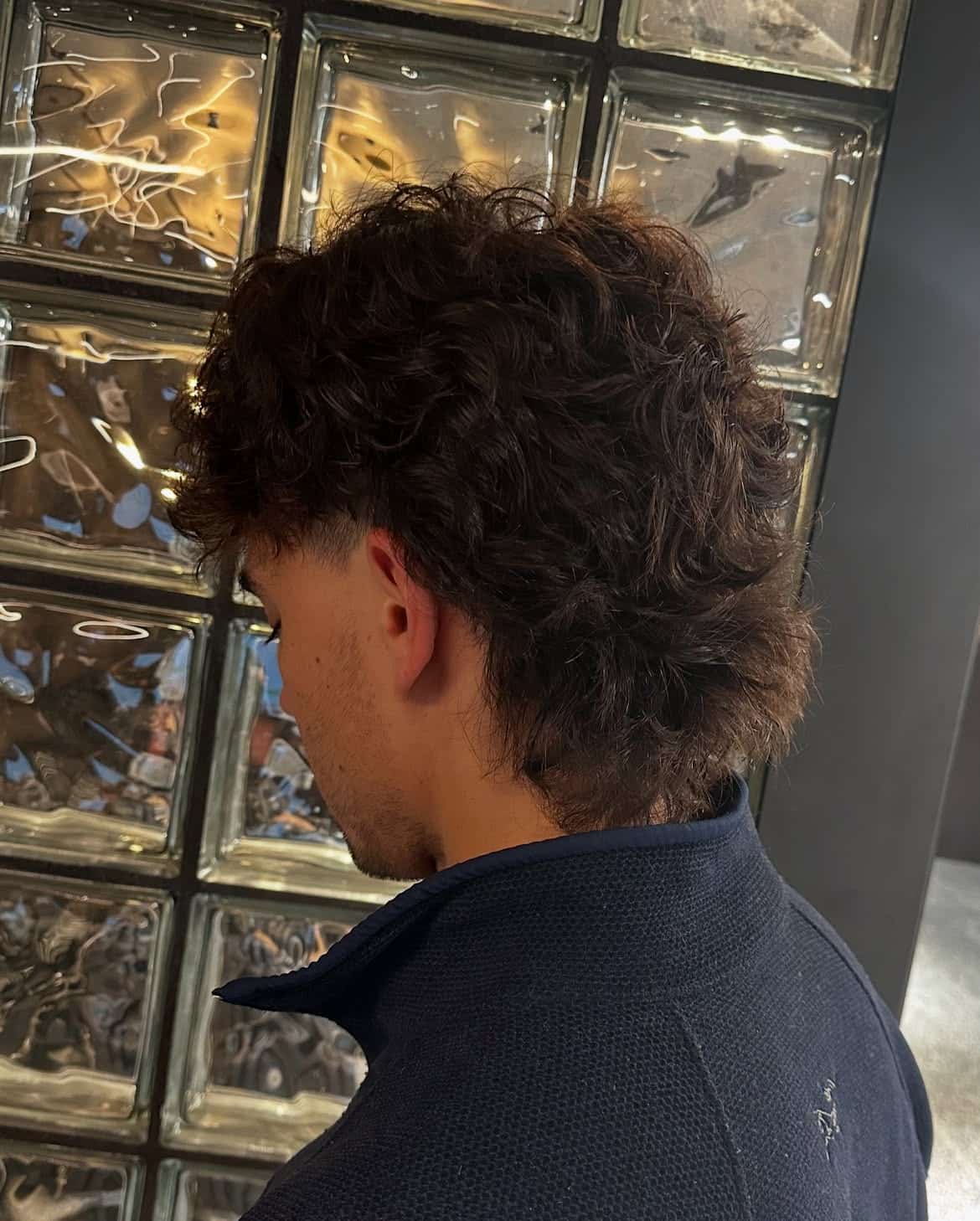 29. Dark Curly Mullet with Soft Ear Taper