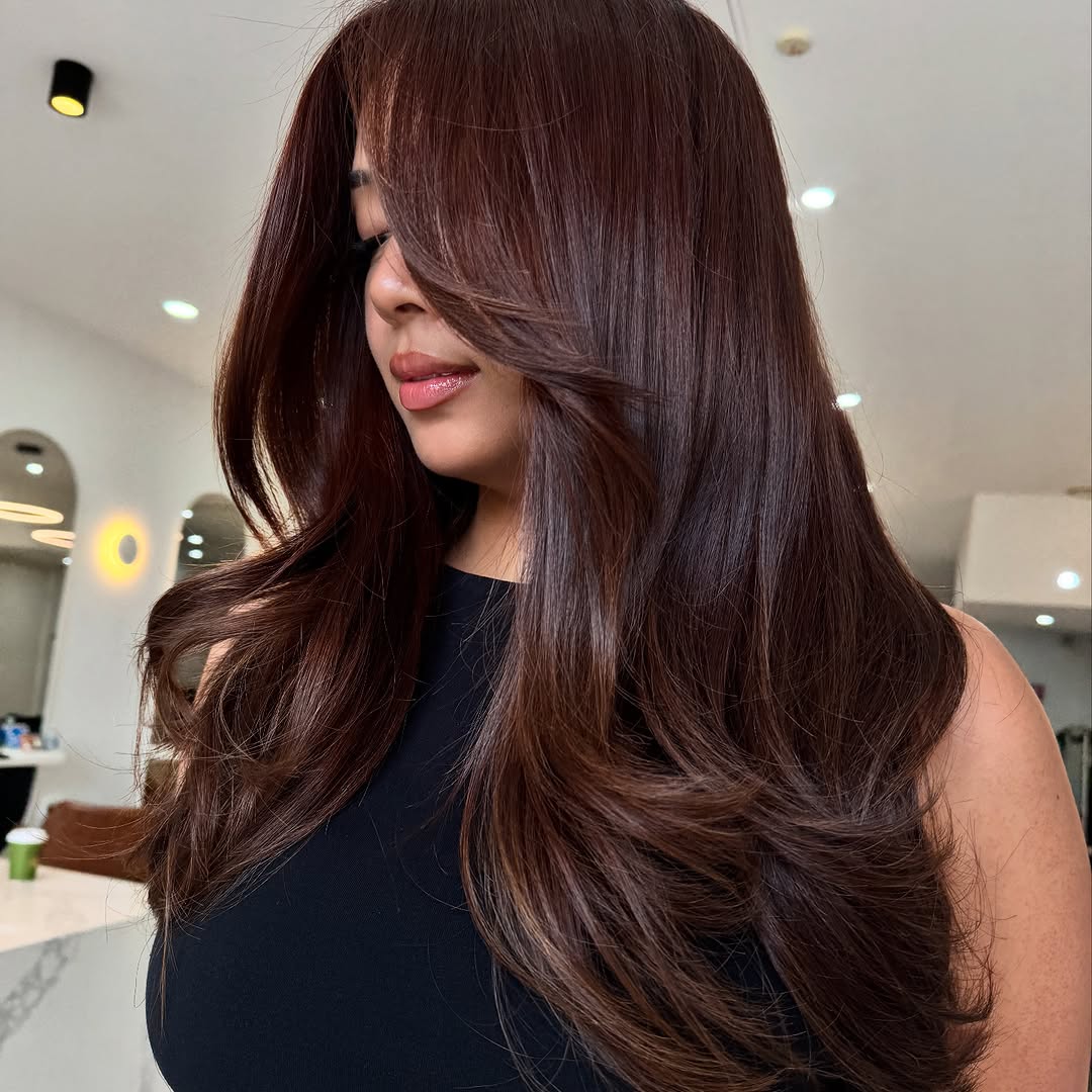 15. Glossy Mahogany Layers with Side-Swept Bangs