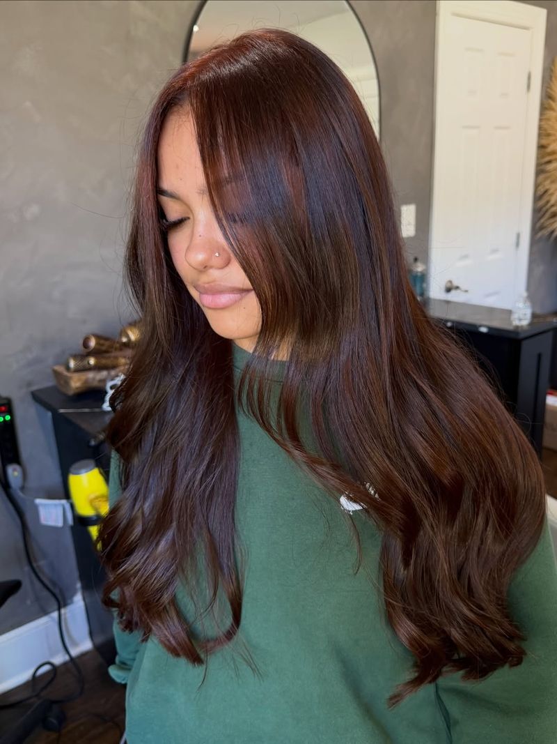 16. Glossy Mahogany Waves with Curtain Bangs