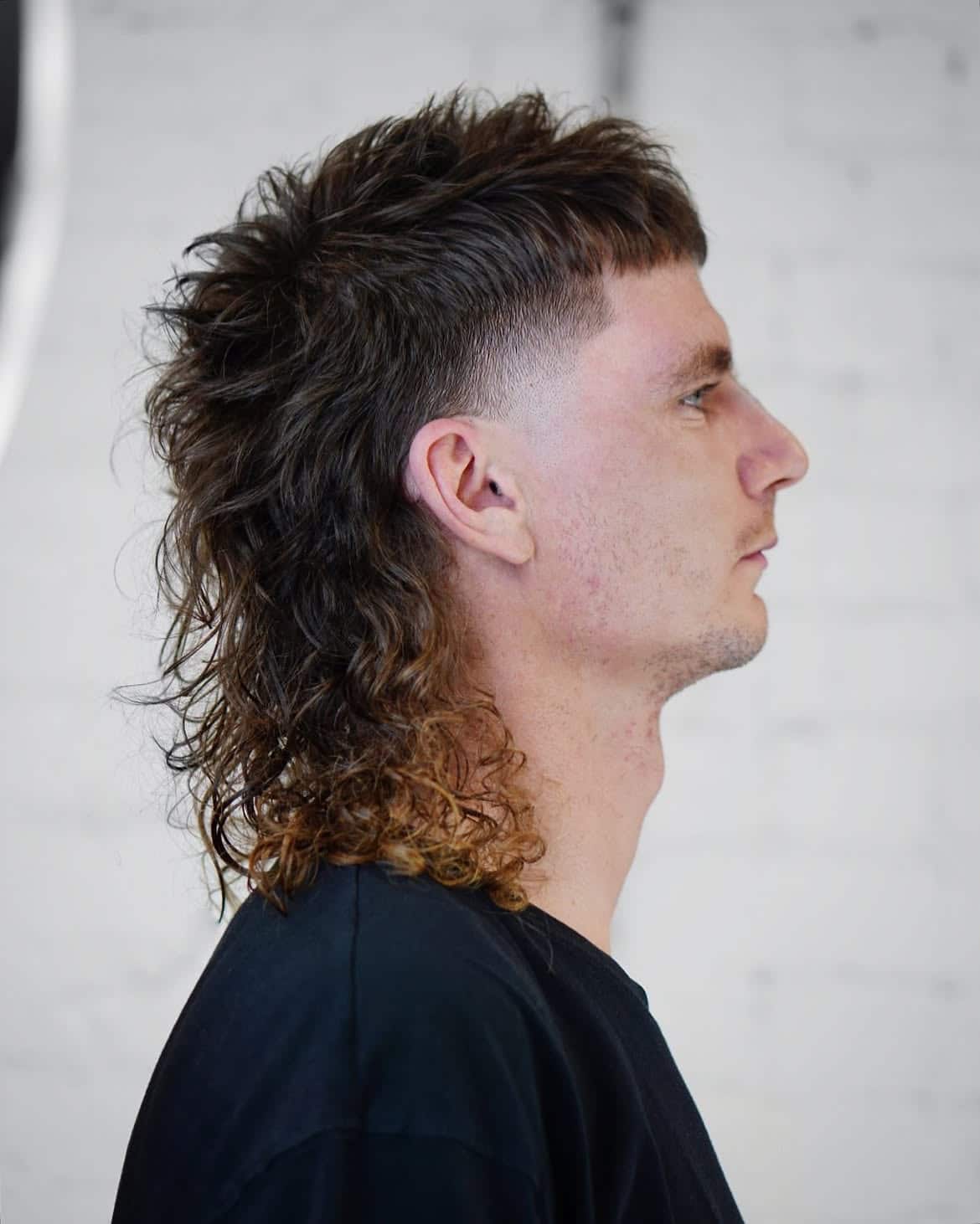 30. High Fade Curly Mullet with Blunt Fringe