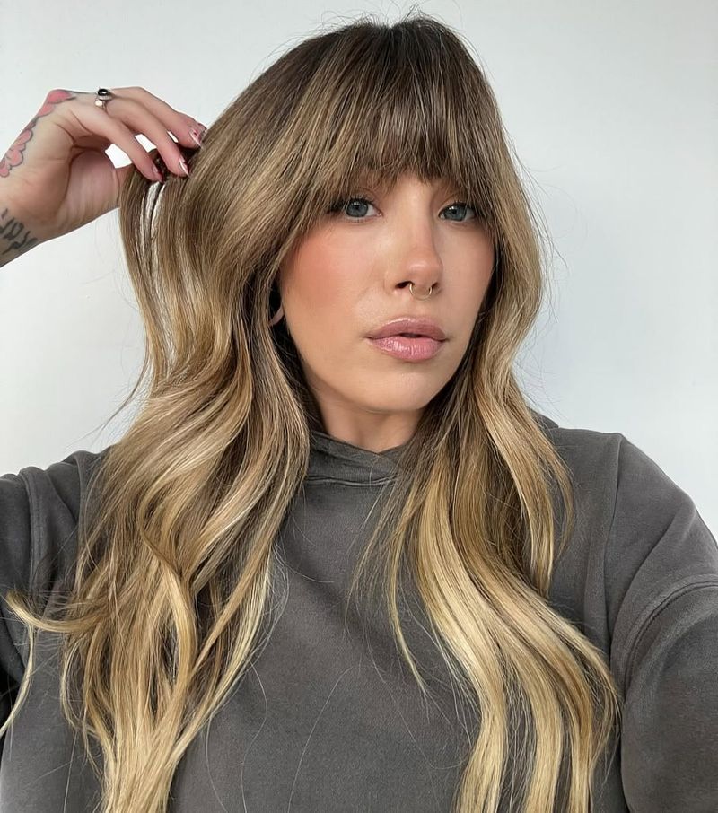 32. Honey Blonde Waves with Full Bangs