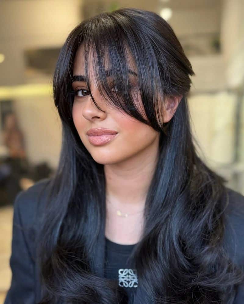 20. Jet Black Butterfly Cut with Wispy Bangs