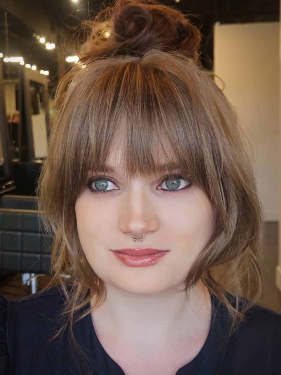 25. Messy Top Knot with Wispy Fringe