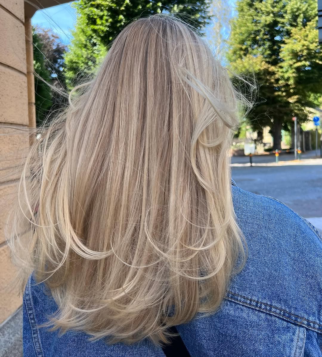 21. Sandy Blonde Long Layers with Face-Framing Wings