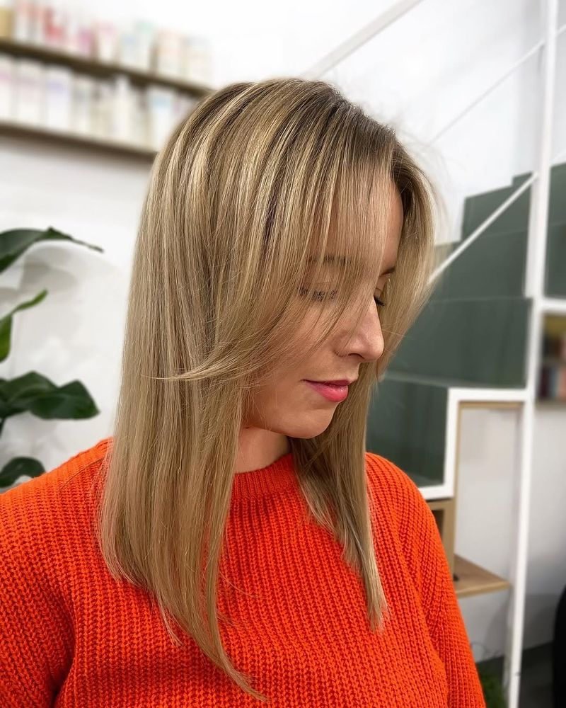 47. Sleek Honey Blonde Straight Cut with Curtain Bangs