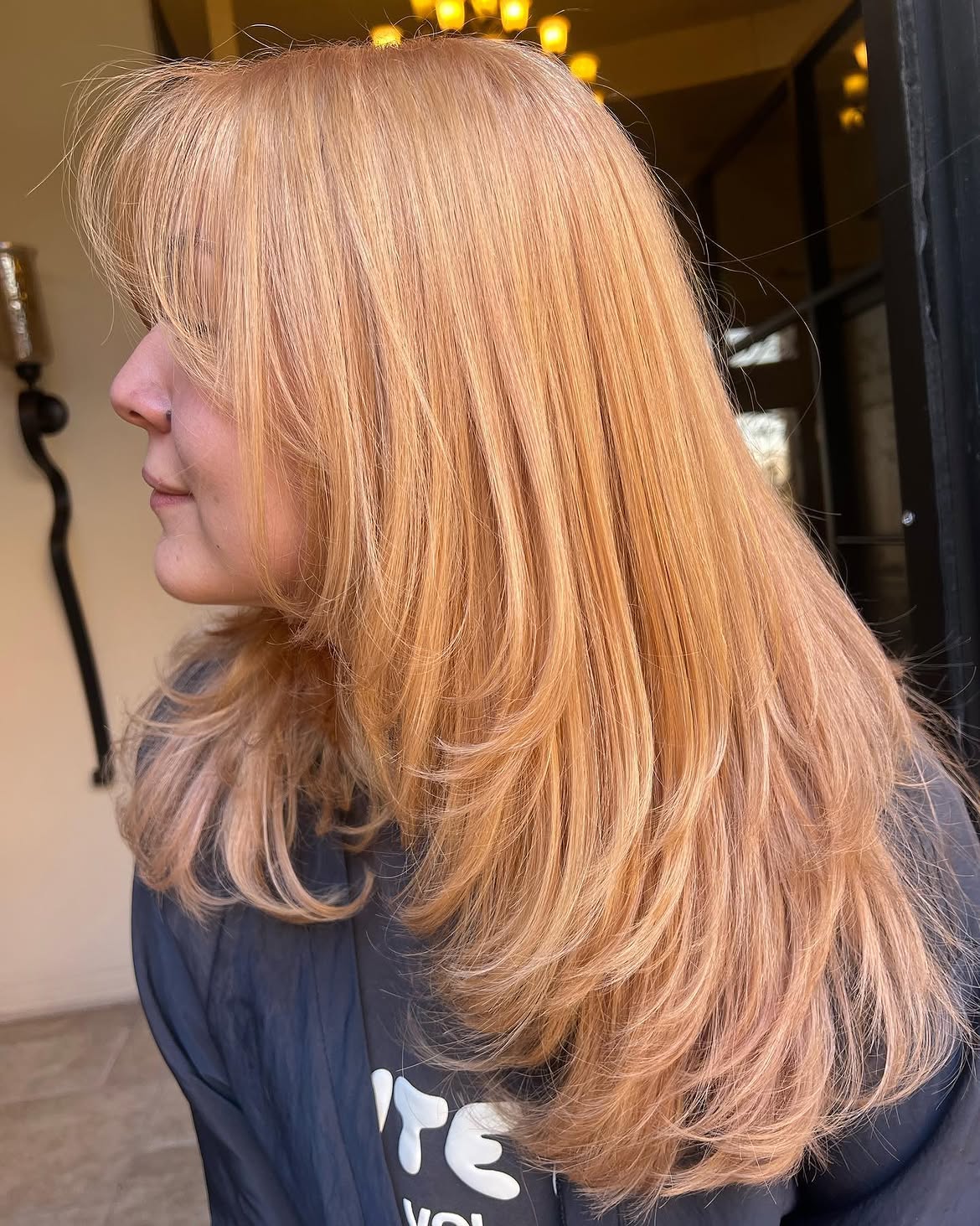 9. Soft Peachy Layers with Bangs