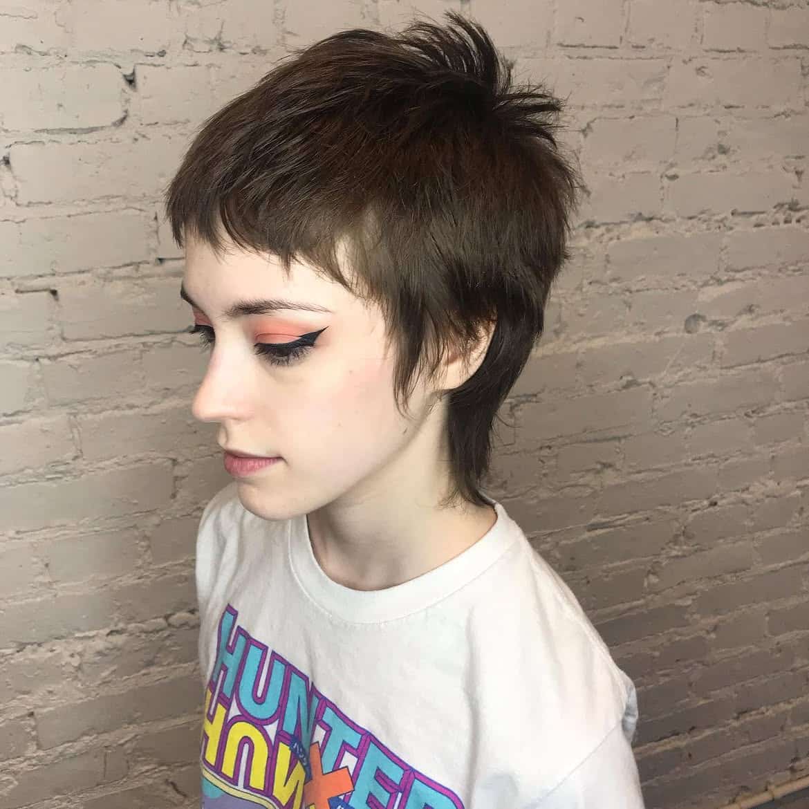 32. Tousled Brunette Pixie Mullet with Micro Bangs
