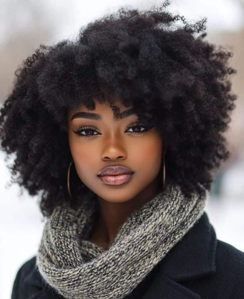 43. Voluminous Curly Afro with Bangs