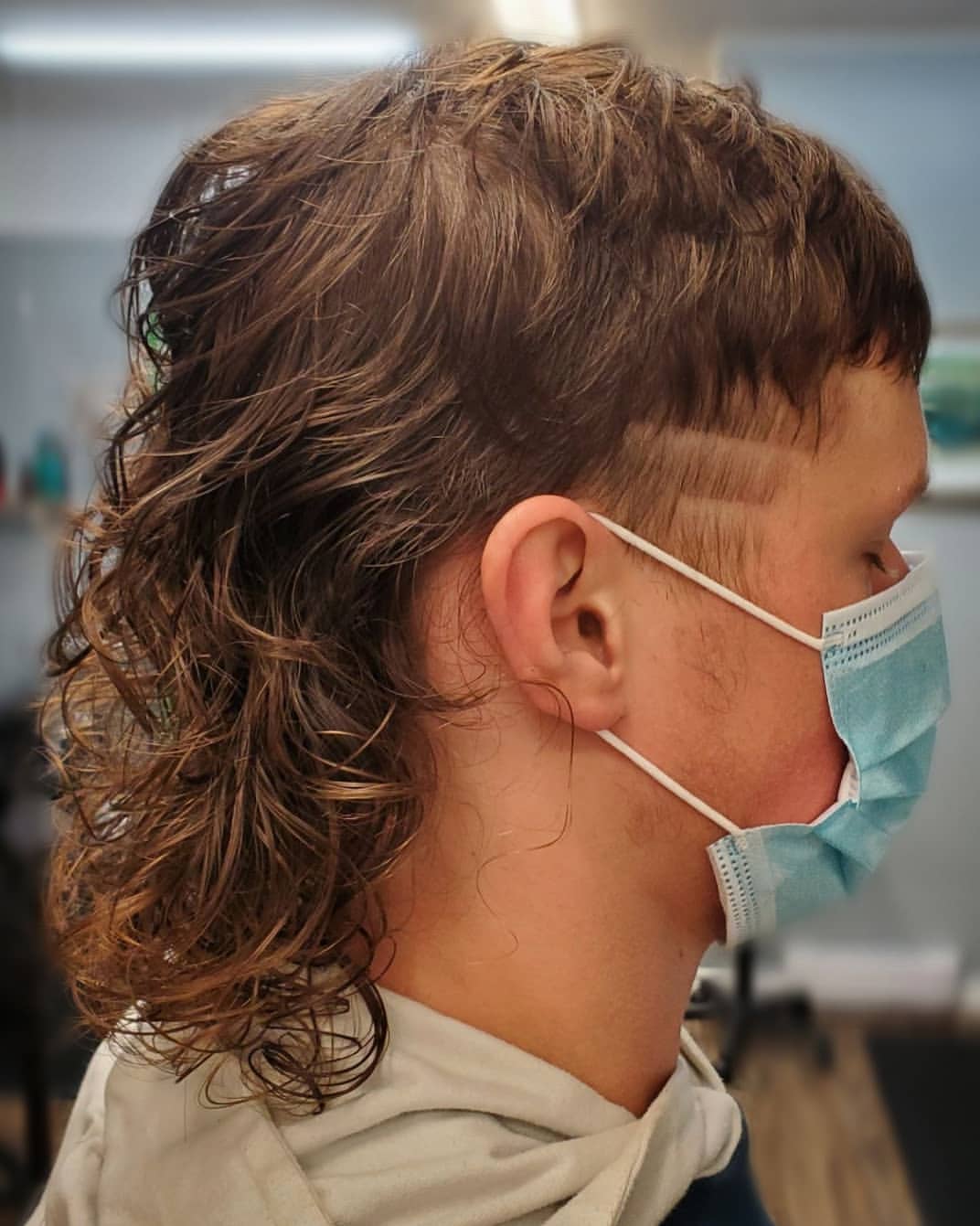 24. Wavy Curly Mullet with Hard Part Fade