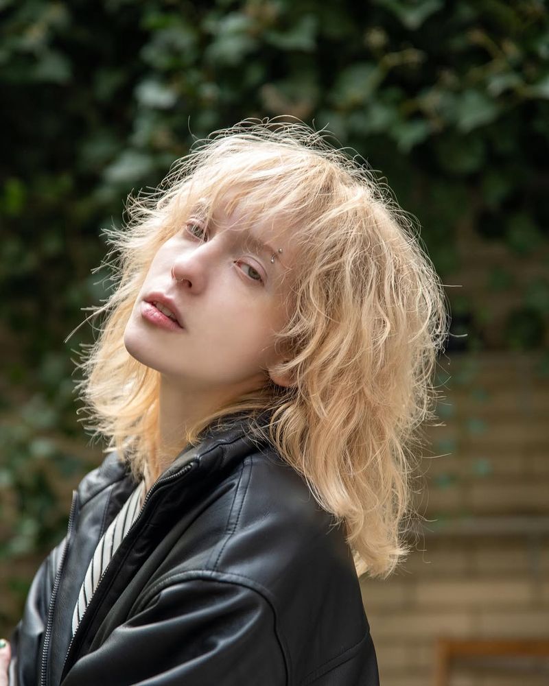 5. Bleach Blonde Shag with Heavy Brow-Skimming Fringe