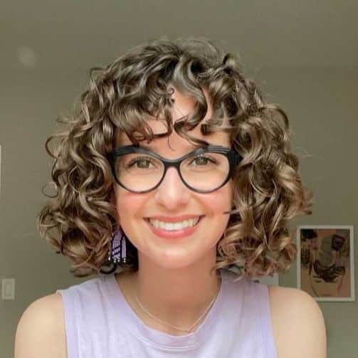 3. Bouncy Brunette Lob with Curly Bangs