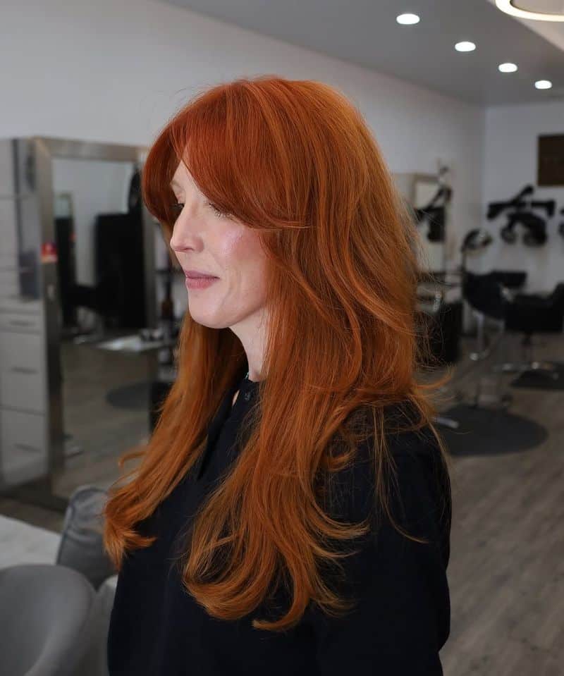 9. Bright Amber Layers with Curtain Bangs