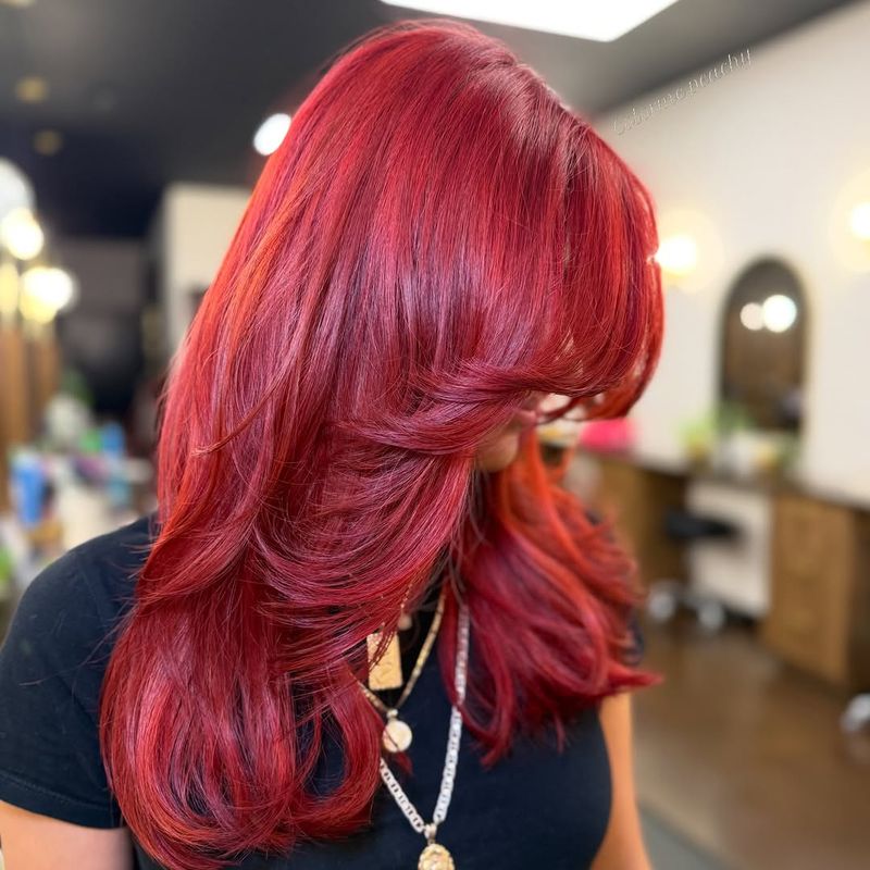 9. Bright Crimson Blowout with Curtained Bangs