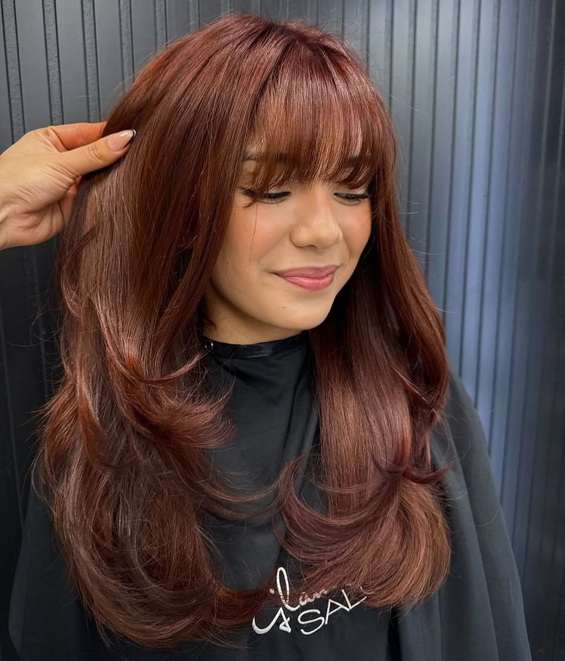 2. Copper Feathered Layers with Soft Bangs