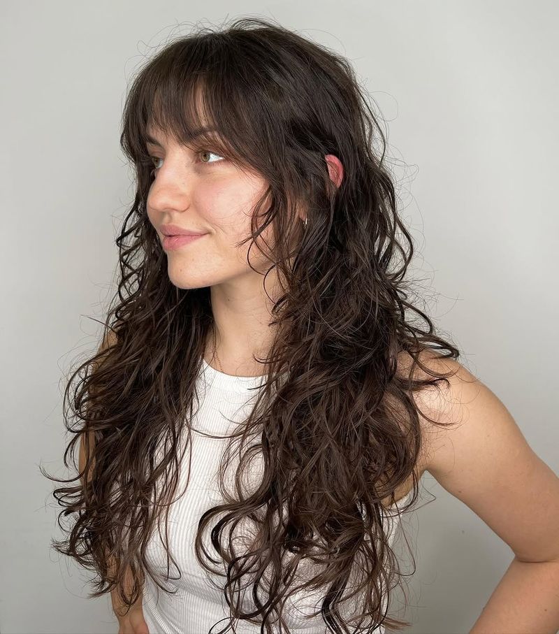21. Dark Brown Curly Shag with Blended Bangs
