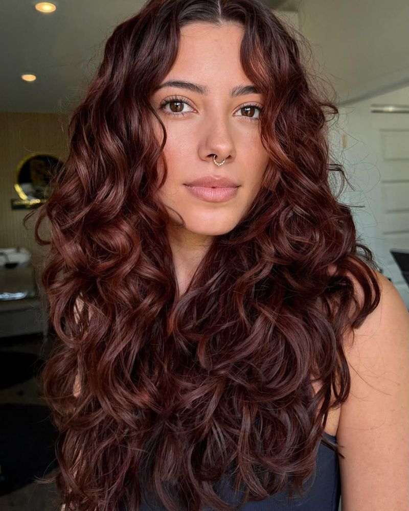 9. Deep Burgundy Curls with Cascading Layers