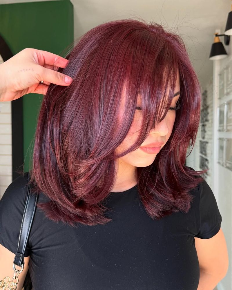 10. Deep Burgundy Layers with Side-Swept Bangs