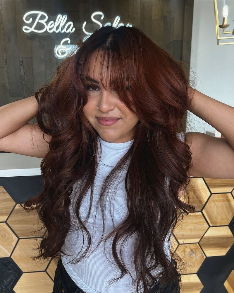 6. Deep Chestnut Curls with Wispy Bangs