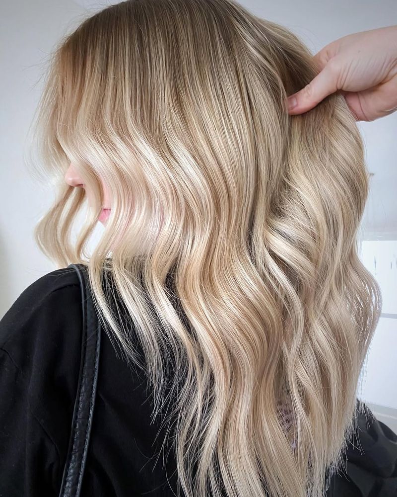 25. Glossy Champagne Waves with Smudged Roots