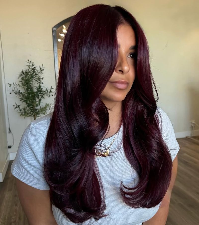 29. Glossy Maroon Waves with Curtain Bangs