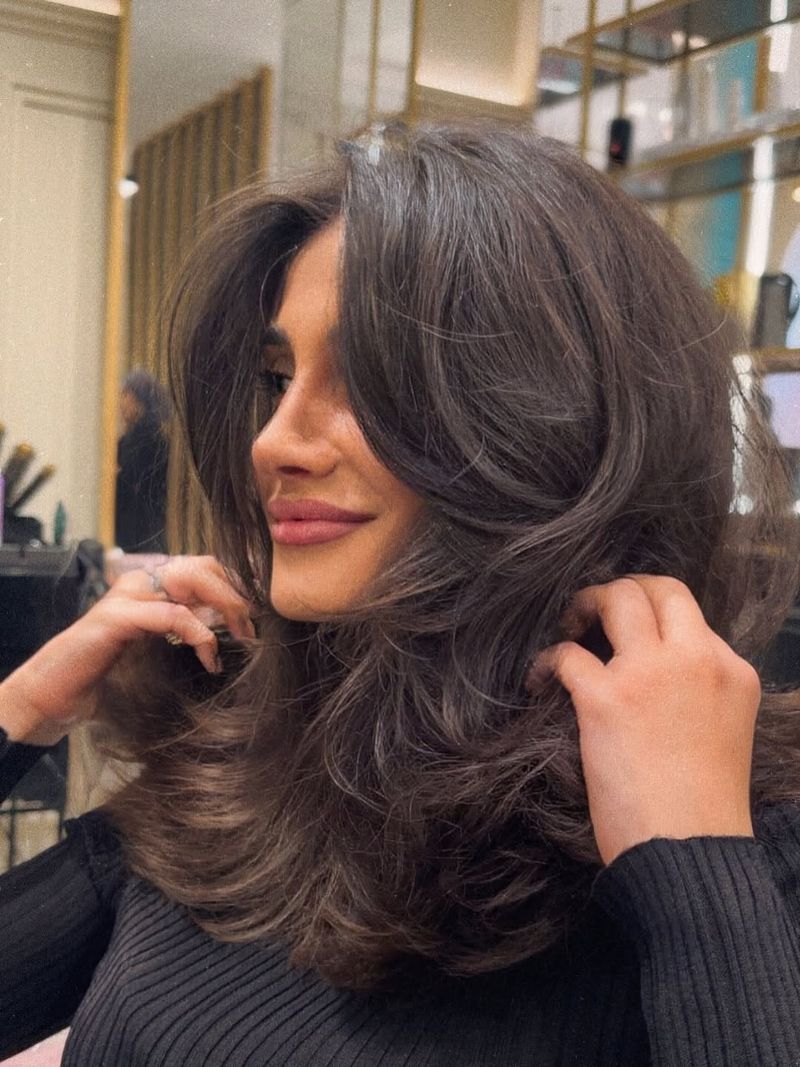 13. Heavy Curtain Bangs and Voluminous Layers