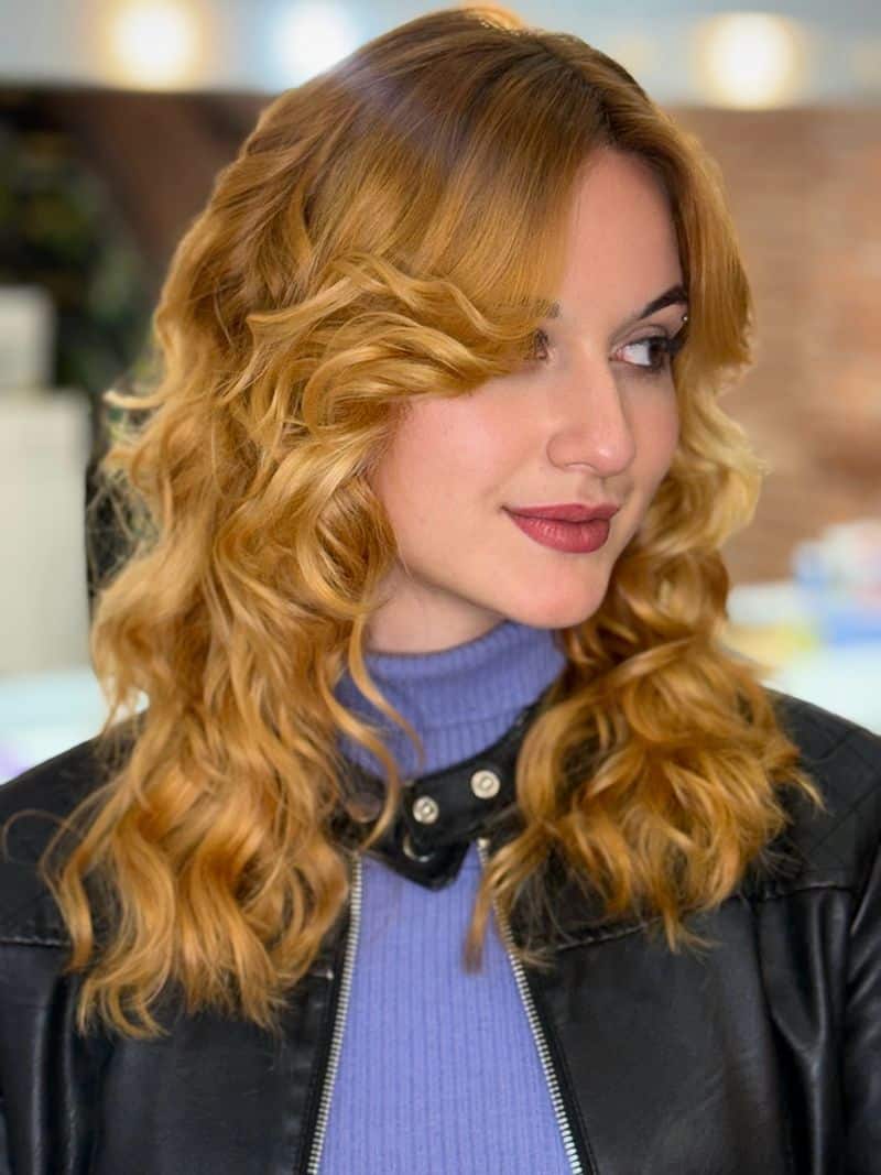 29. Honey Blonde Waves with Curtain Bangs