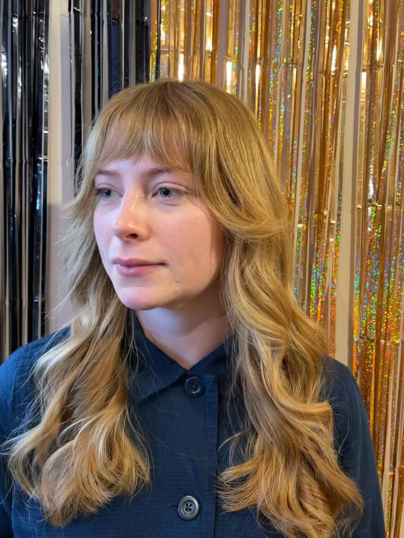 8. Honey Blonde Winged Layers with Brow-Skimming Fringe