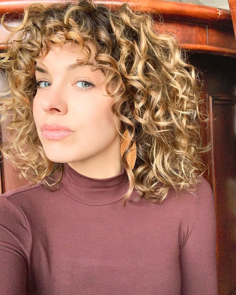 43. Honey-Hued Curly Lob with Bangs