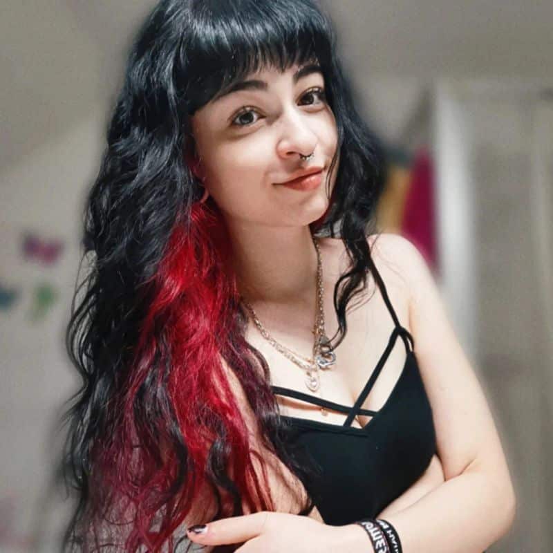 26. Jet Black Curls with Vivid Red Peekaboo Highlights