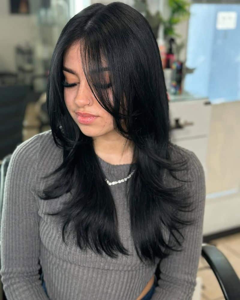 27. Jet Black Feathered Layers with Wispy Bangs