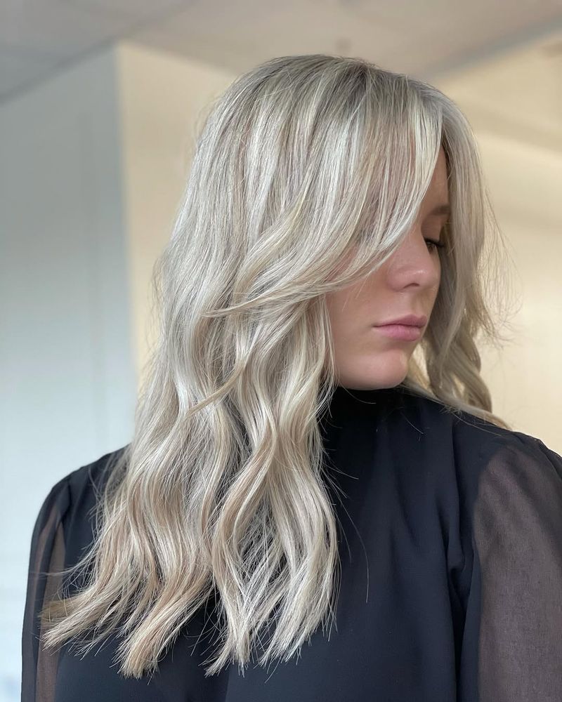 6. Platinum Blonde Waves with Long Fringe