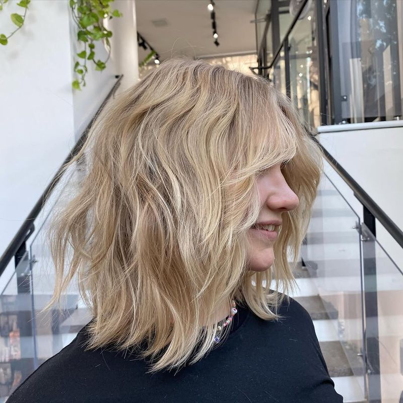 26. Sandy Blonde Shag with Curtain Bangs
