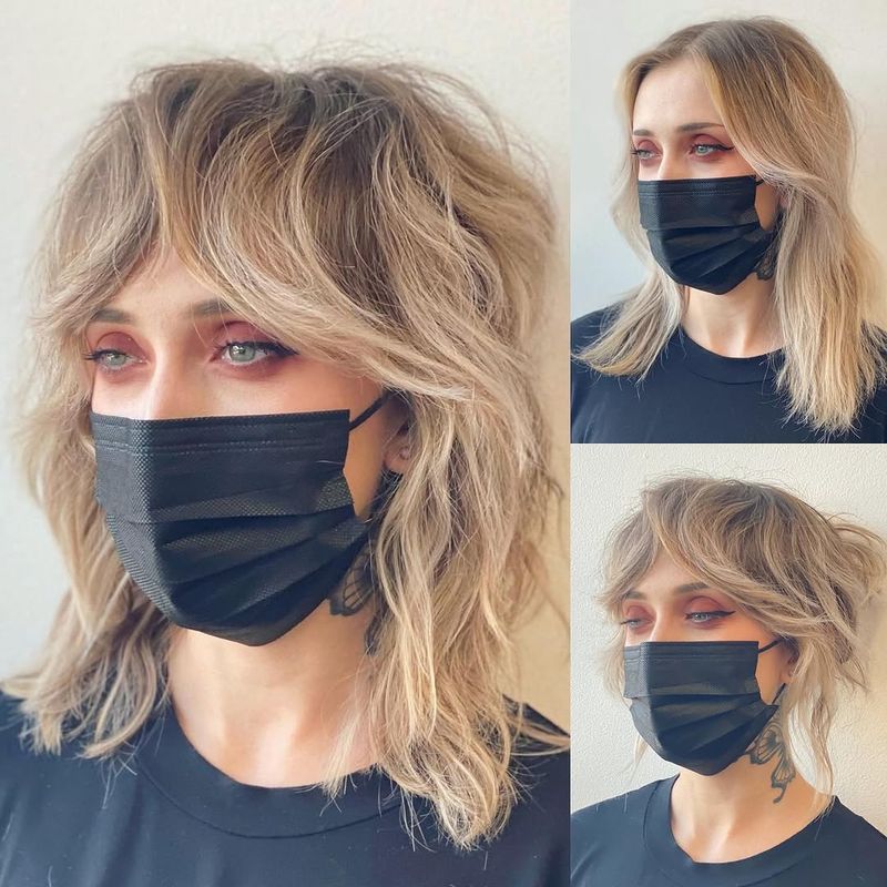 10. Sandy Blonde Wolf Cut with Heavy Curtain Bangs