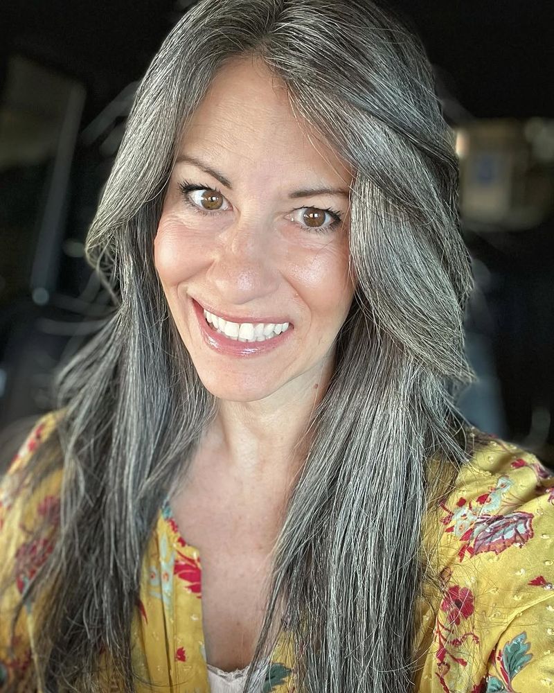 26. Silver-Streaked Long Layers with Sweeping Bangs