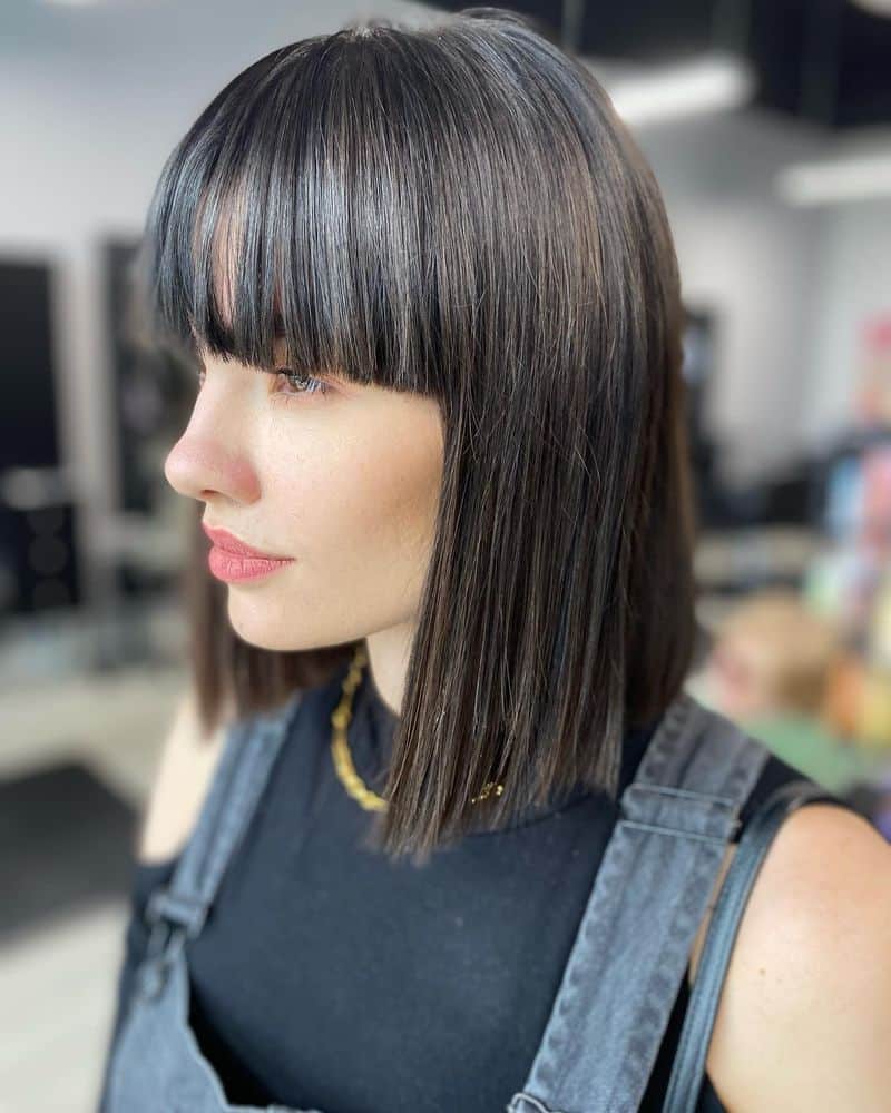 9. Sleek Dark Chocolate Lob with Heavy Bangs