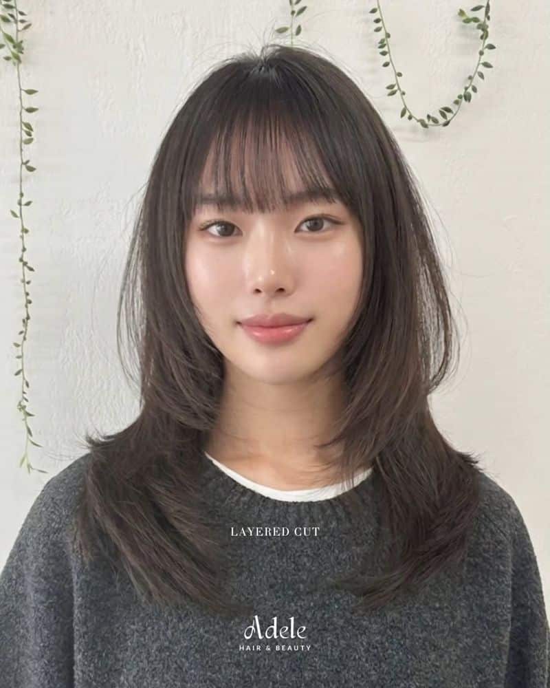 10. Soft Feathered Layers with Wispy Bangs