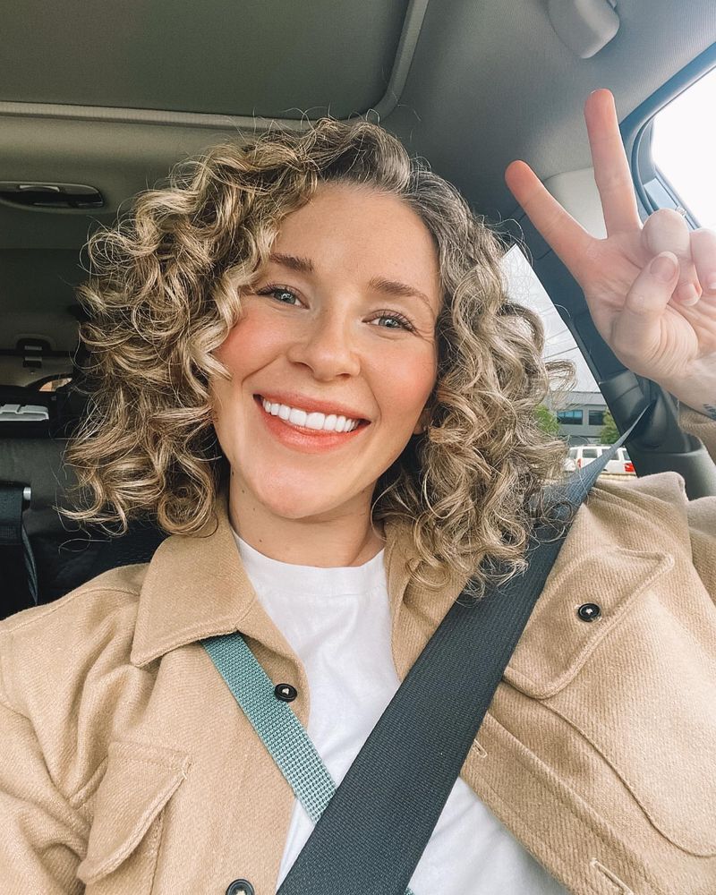 32. Sun-Kissed Spiral Curls with Deep Side Part