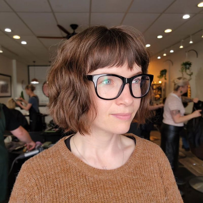 43. Textured Chestnut Bob with Brow-Grazing Bangs