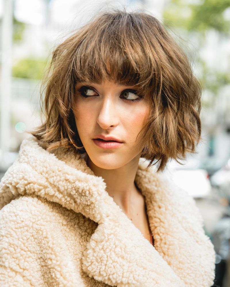 44. Tousled Caramel Bob with Brow-Grazing Bangs