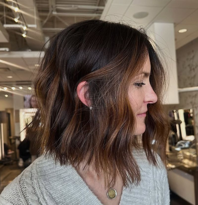 40. Tousled Chestnut Bob with Warm Caramel Highlights