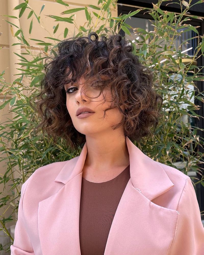 28. Tousled Dark Curls with Full Bangs
