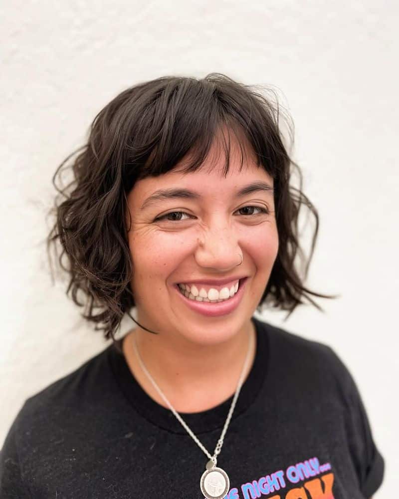 28. Tousled Dark Curls with Micro Bangs